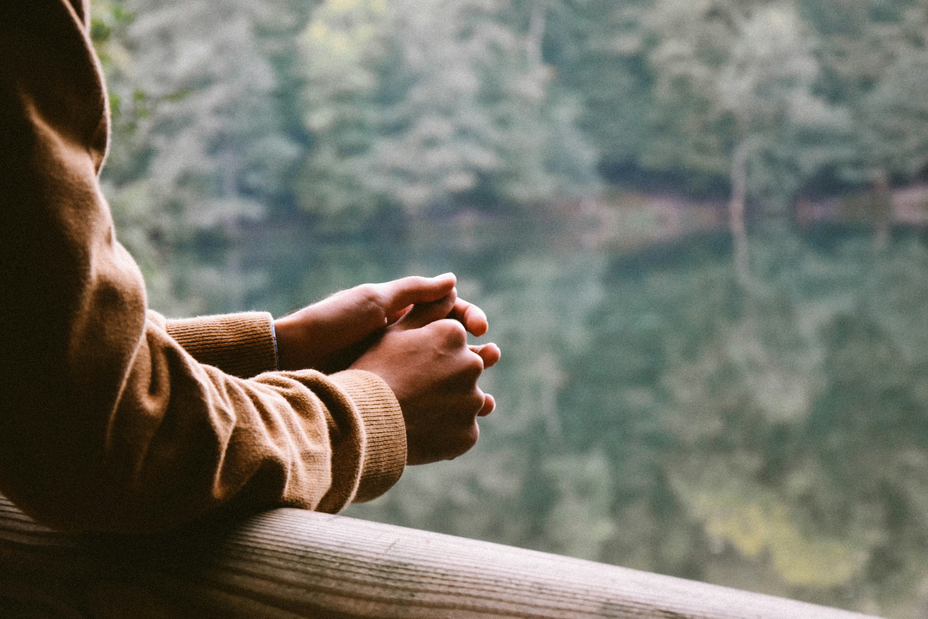 Person holding their hands together contemplatively